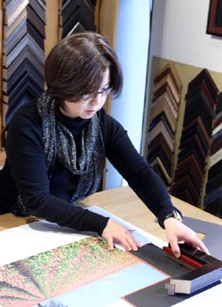 Owner Hong Zhu designs framing for a print